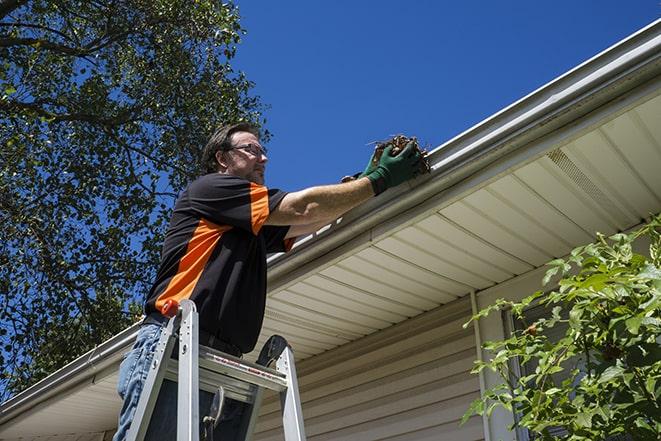 home improvement expert fixing gutters on a roof in Alsip