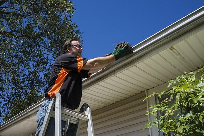 home maintenance worker repairing a leaky gutter in Chicago Heights IL